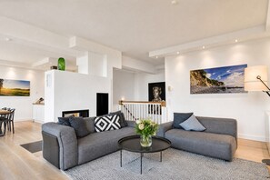 A modern living room with a grey sofa, a coffee table, and a fireplace.