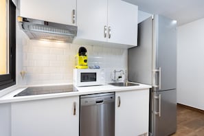 A modern kitchen with white cabinets, stainless steel appliances, and a dishwasher.