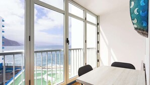 A balcony with a view of the sea and a building across the water. - Apartamento Zoraida del mar (Mesa del Mar)