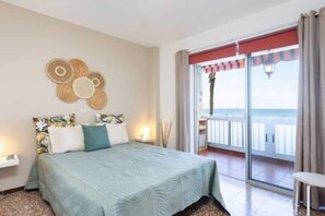 Ein Hotelzimmer mit Bett, Nachttisch, Wanddekoration und Balkon mit Blick.