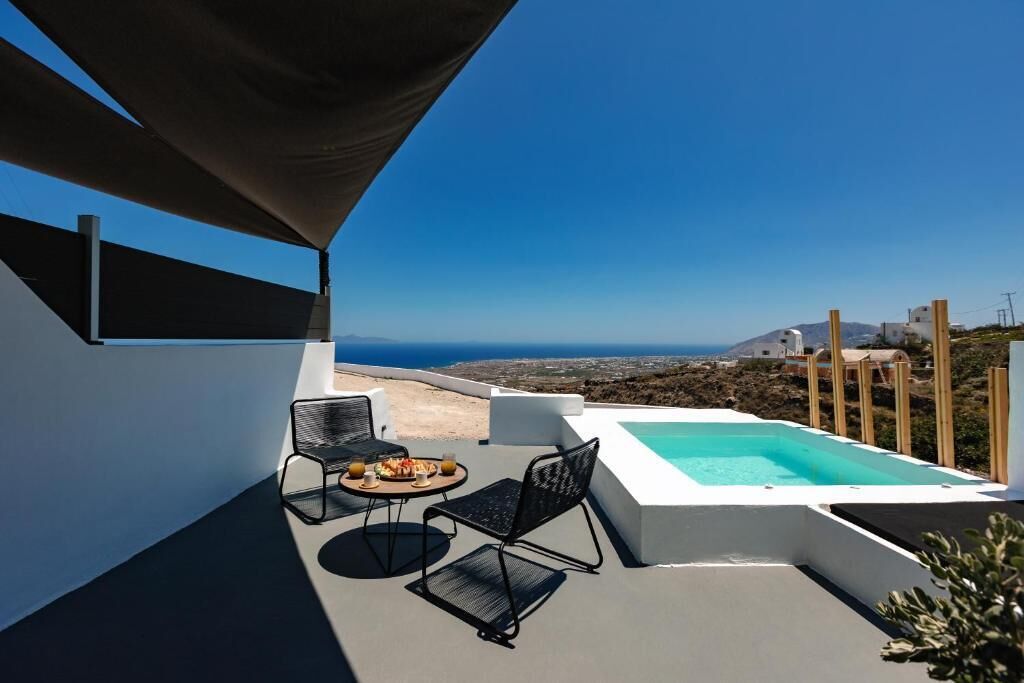 Terraza en la azotea con piscina, dos sillas y una mesa con comida.