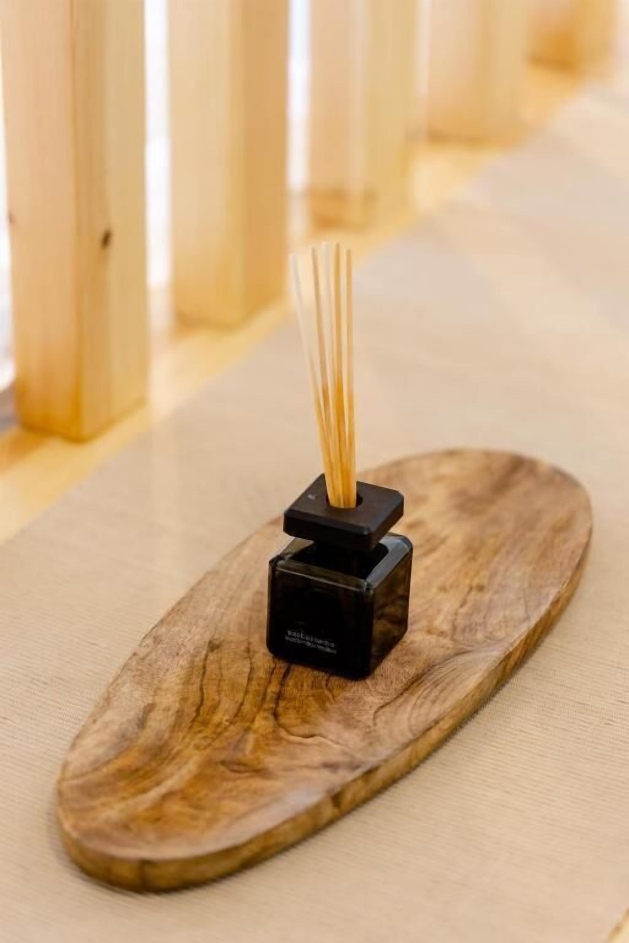 A wooden tray with a black object on it, possibly a speaker or a small electronic device.