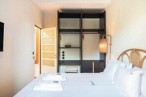 A hotel room with a bed, a wardrobe, a nightstand, and a lamp. - Liiiving in Porto - Casa Duque Apt I (Porto)