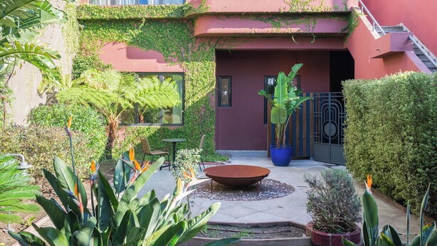 A courtyard with a circular seating area, potted plants, and a staircase leading to an upper level. - Liiiving in Porto - Casa Duque Apt I (Porto)