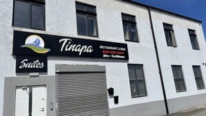 A building with a sign for 'Tinapa Restaurant & Bar' and 'Suites'.
