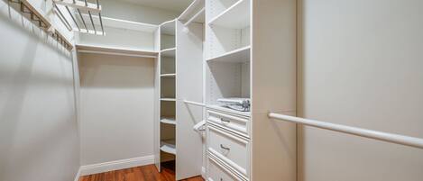 Ein begehbarer Kleiderschrank mit offenen Regalen, Schubladen und Kleiderstange.