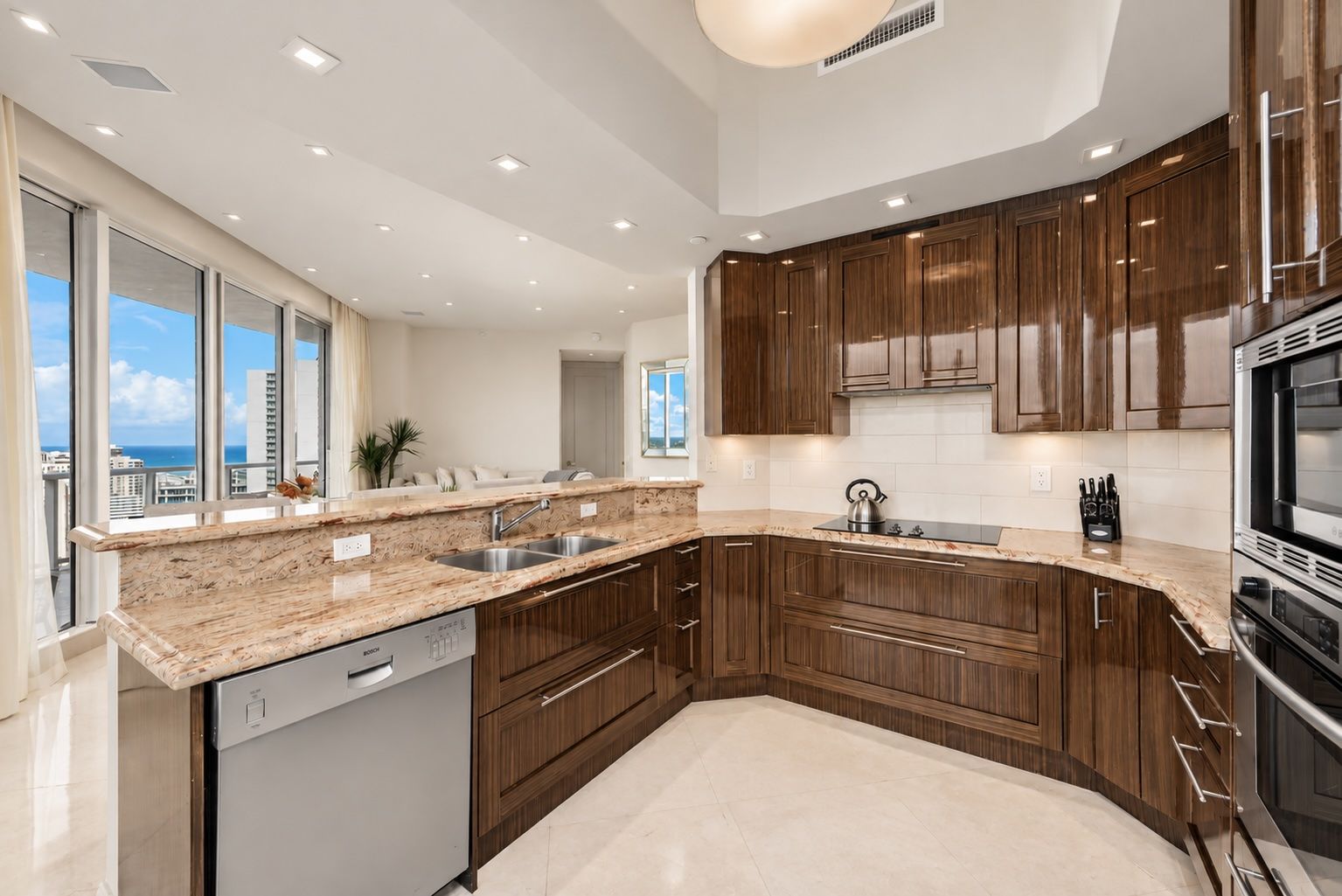 A modern kitchen with a dishwasher, double sink, and stainless steel appliances.