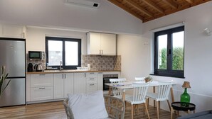 Eine moderne Küche mit weißen Schränken, einer eingebauten Mikrowelle und einem großen Fenster.