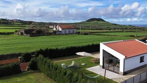 A modern house with a red roof, a garden with a hammock, and a view of the countryside. - Bird House by PontaNegraAzores (Angra do Heroísmo)