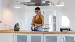 Una cocina moderna con una campana de acero inoxidable, una encimera de madera y una planta en maceta.