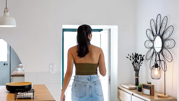 A modern kitchen with a dining table, a hanging light fixture, and a decorative mirror. - Casa da Gente T2 by PontaNegraAzores (Praia da Vitória)