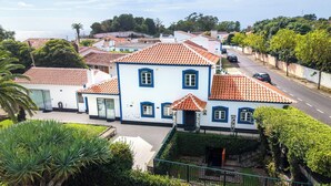 A coastal residential area with houses featuring red-tiled roofs and blue accents. - Quinta São José - Duplo/Twin 5 (Angra do Heroísmo)