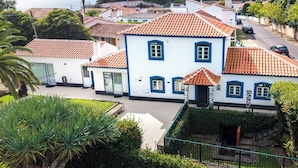 A residential area with white houses, red-tiled roofs, and a clear sky.