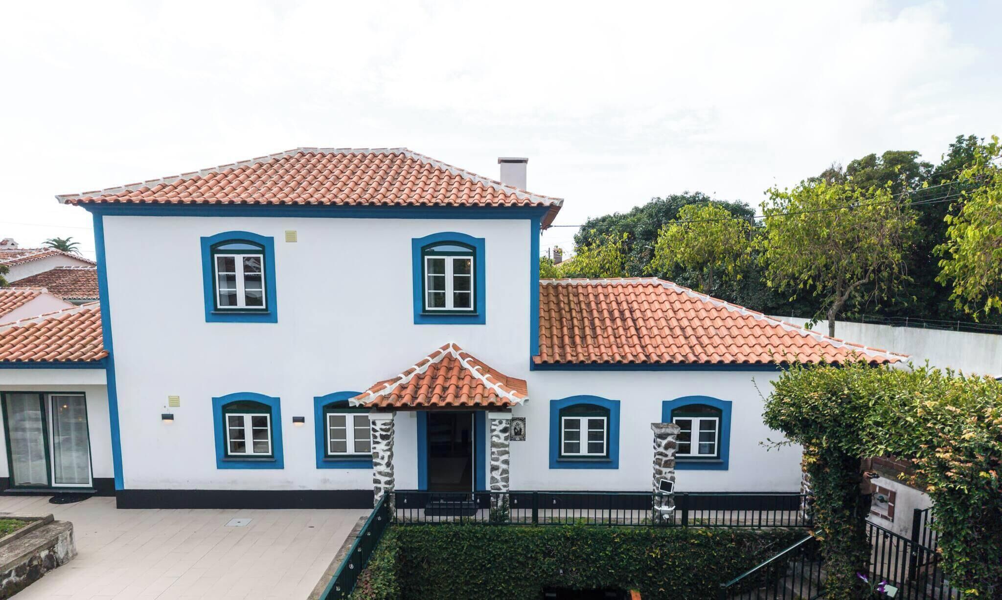 Un bâtiment à deux étages, doté d’un toit en tuiles, de nombreuses fenêtres et d’une entrée fermée par un portail.