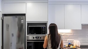 Una cucina moderna con elettrodomestici in acciaio inossidabile, tra cui un frigorifero, un forno a microonde e un forno.