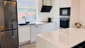 A modern kitchen with a stainless steel refrigerator, a dishwasher, a microwave, and an oven. - City House 2 by PontaNegraAzores (Angra do Heroísmo)