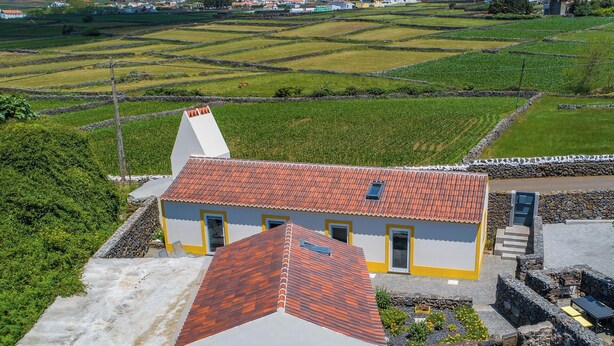 Ein ländliches Haus mit roten Ziegeln, Steinmauern und einem kleinen Garten.