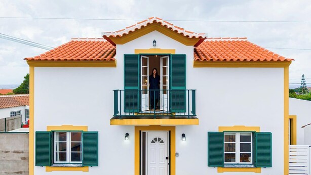 A two-story building with a balcony, a white door, and green shutters. - The Biscuit House T2 by PontaNegraAzores (Praia da Vitória)