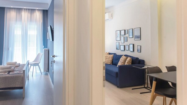 A modern living room with a sofa, a dining table, and a TV. - Speranza by halu! (Thessaloniki)