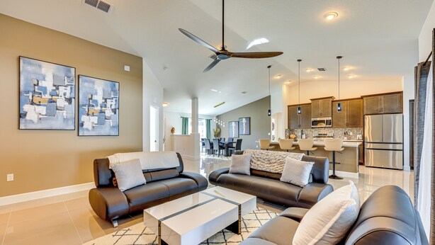 A modern living room with a sofa set, a coffee table, and a ceiling fan. - 8 Mi to Flagler Beach: Home w/ Outdoor Dining! (Palm Coast)