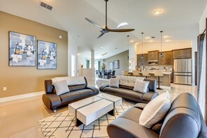 A modern living room with a sofa set, a coffee table, and a ceiling fan. - 8 Mi to Flagler Beach: Home w/ Outdoor Dining! (Palm Coast)