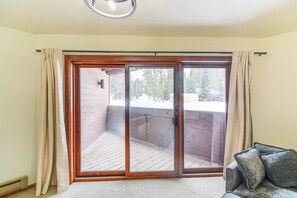 A room with a sliding glass door leading to a wooden deck. - Walk to Winter Park Resort: Condo w/ Hot Tub! (Winter Park)