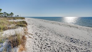 A beach with white sand and sparse vegetation. - Endless Summer: Windmark Beach Home Steps to Shore (Port St. Joe)