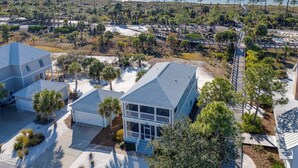 A coastal residential area with houses, a beach, and a clear view of the ocean. - Endless Summer: Windmark Beach Home Steps to Shore (Port St. Joe)
