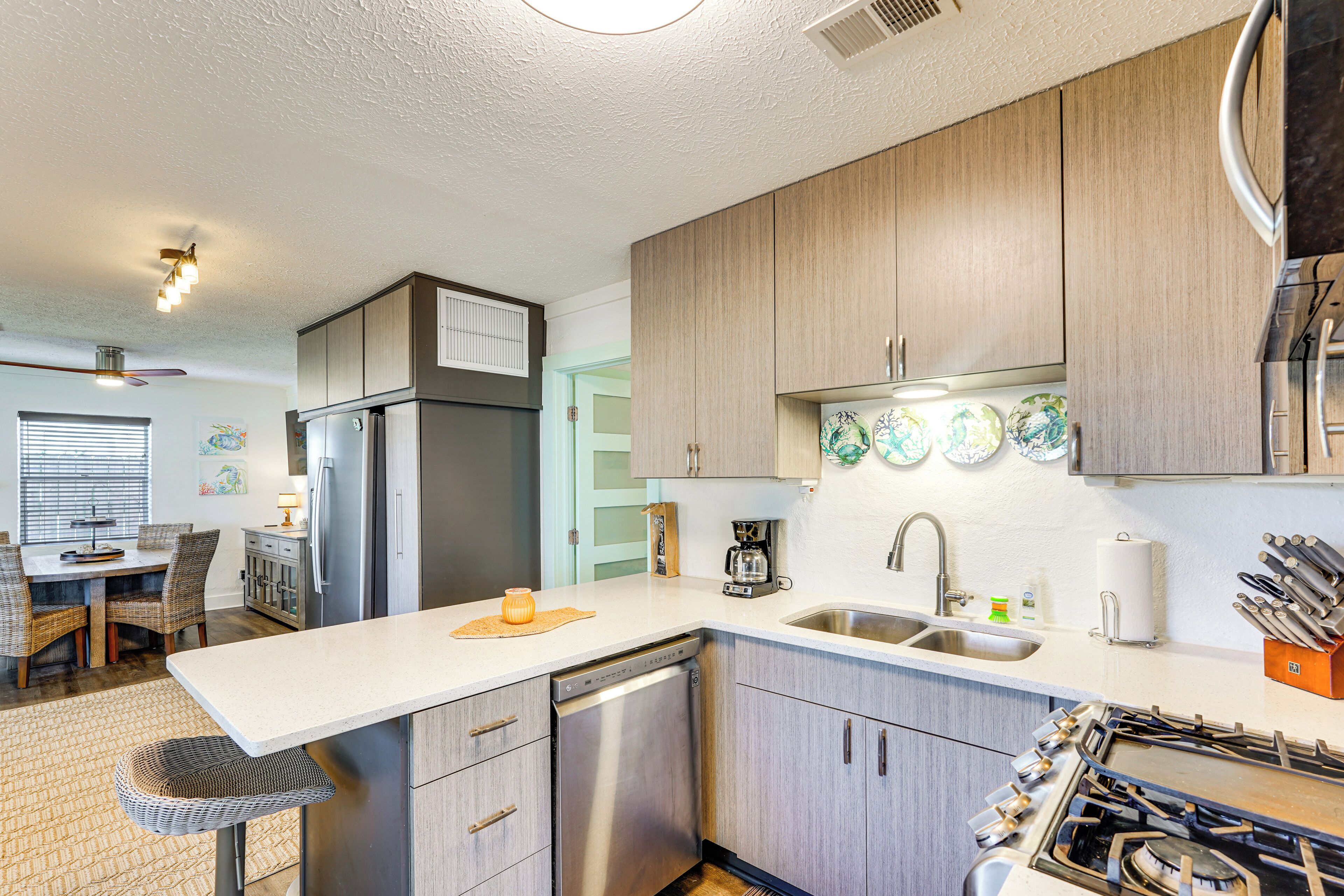 A modern kitchen with wooden cabinets, a dishwasher, a stove, and a sink.