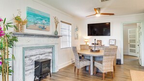 A dining area with a fireplace, wicker chairs, and a ceiling fan. - < 1 Mi to Beach: Family-friendly Port St Joe Home (Port St. Joe)