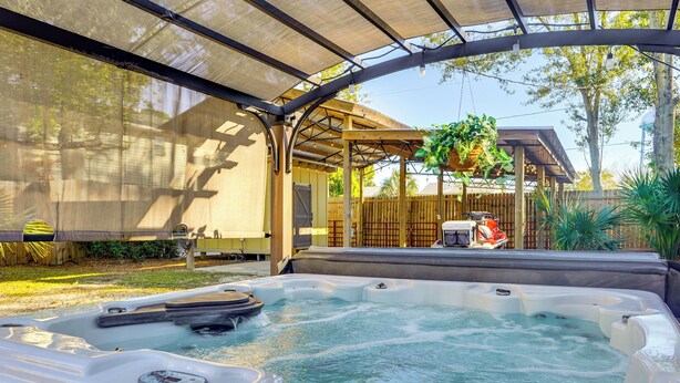 A hot tub under a covered patio with a wooden deck and a hanging plant. - < 1 Mi to Beach: Family-friendly Port St Joe Home (Port St. Joe)
