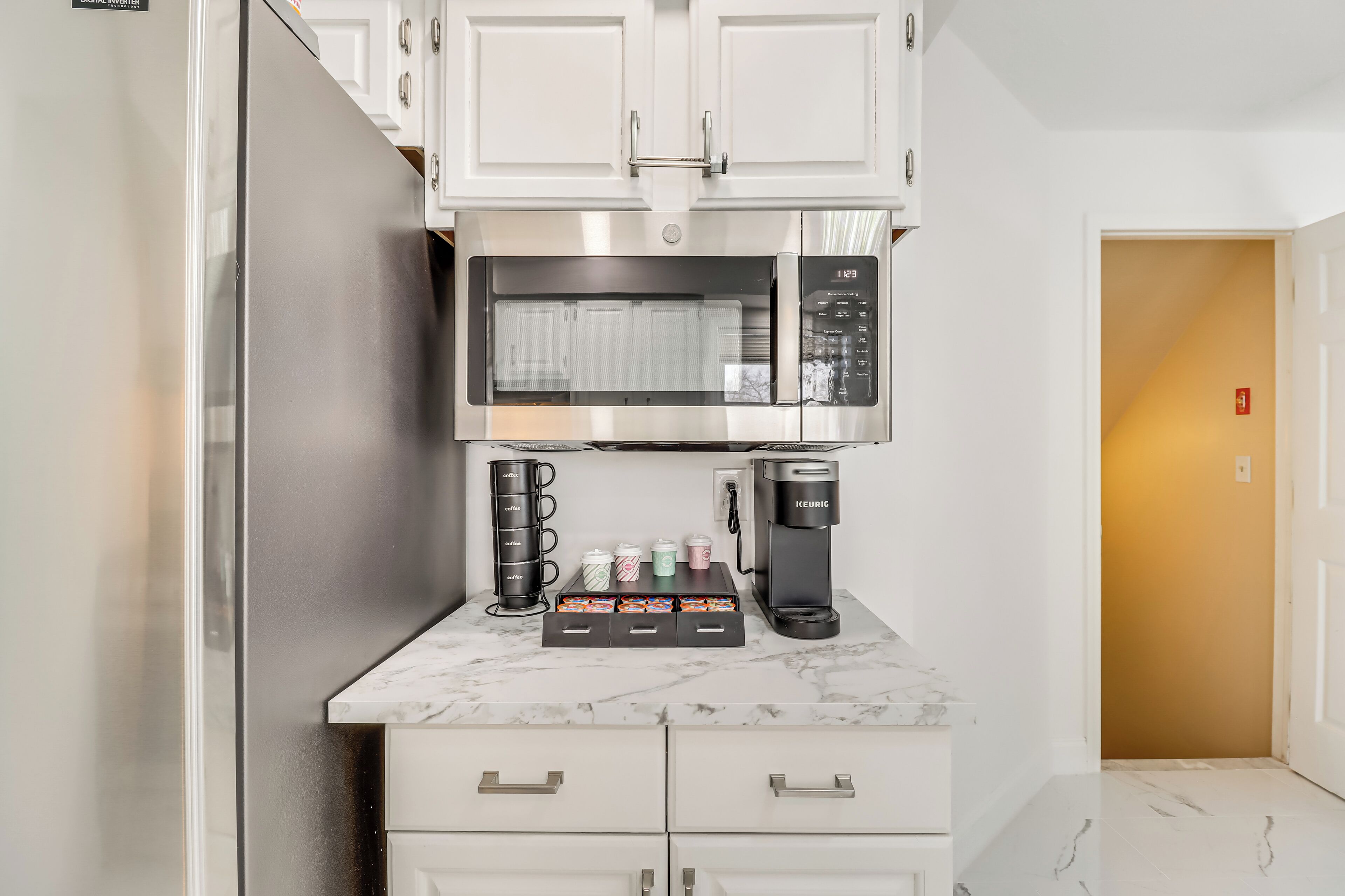 A compact kitchen with a built-in microwave, coffee maker, and storage drawers.