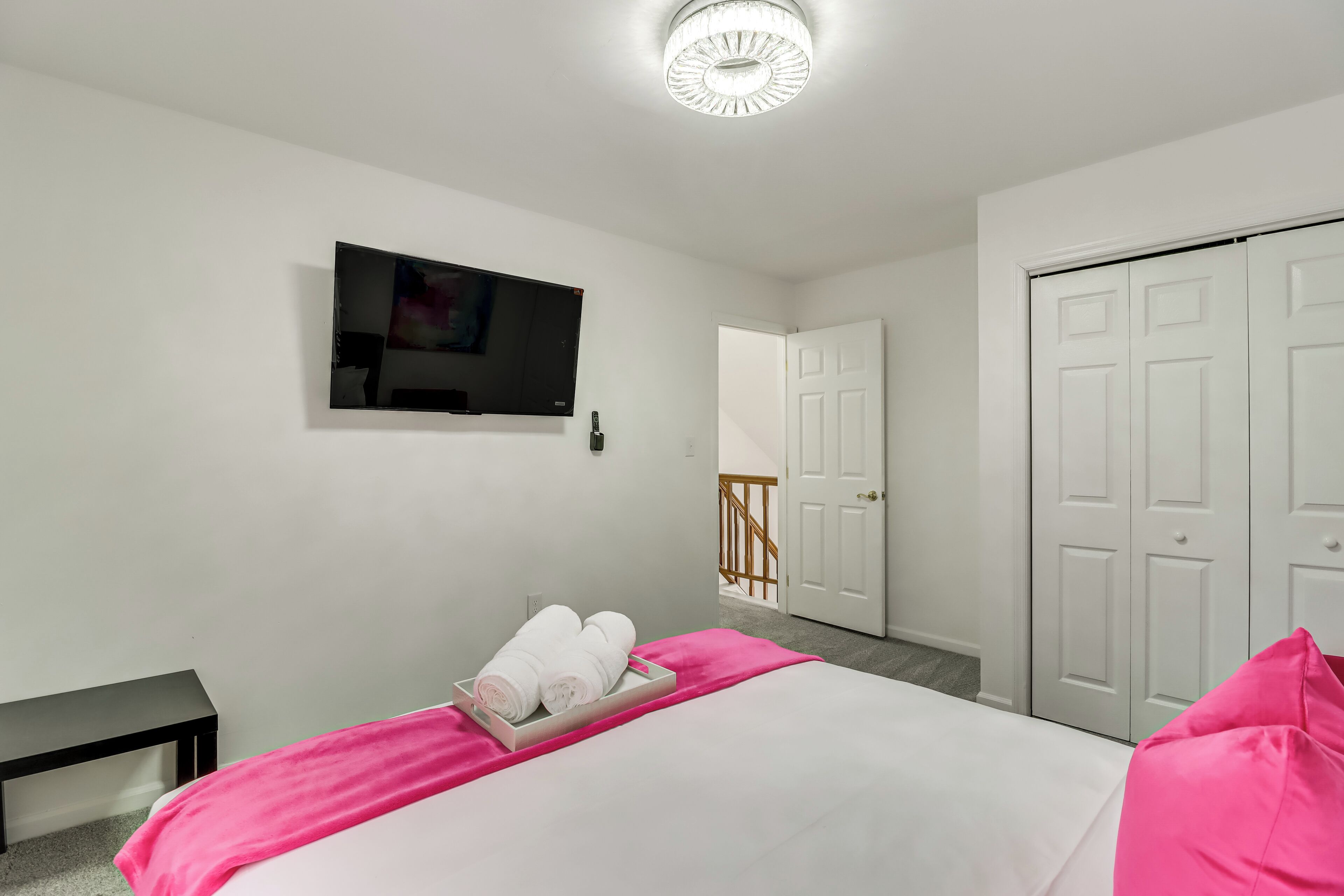 A hotel room with a bed, a TV, a wardrobe, and a staircase.