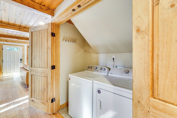 A laundry room with wooden walls and a sloped ceiling. - Hot Tub + Fireplace: Cozy Angel Fire A-frame Cabin (Angel Fire)