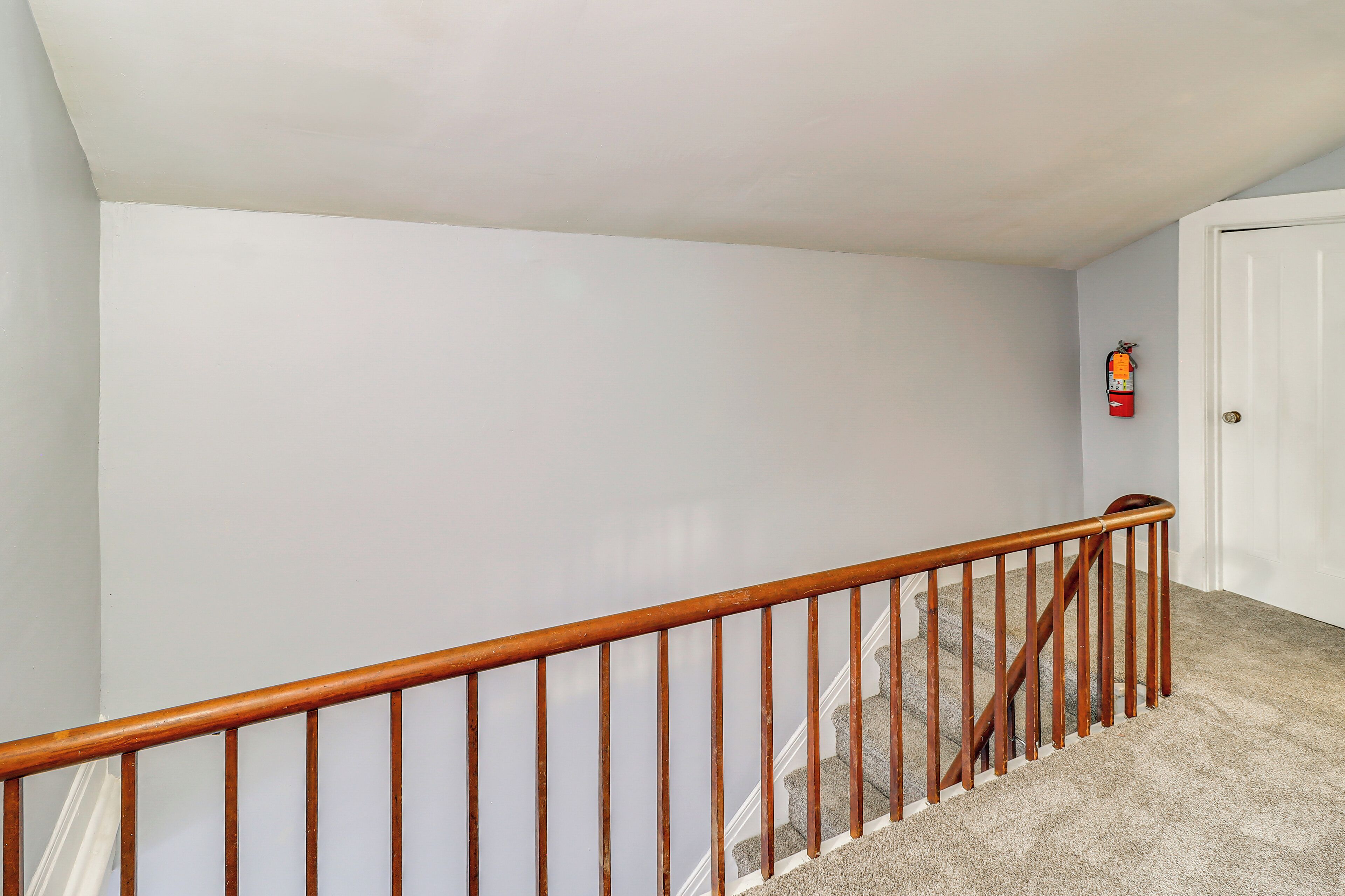 A staircase with a wooden handrail leading to a landing.