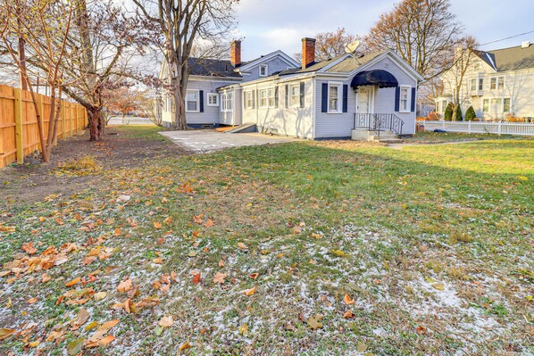 A two-story house with a front porch, a small attached garage, and a fenced yard. - 1 Block to Downtown Adrian: Spacious Home! (Adrian)
