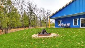 A blue house with a fire pit in the yard and outdoor seating. - 2 Mi to Lake Michigan: Fire Pit, Grill, Patio! (Green Bay)