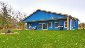 A blue house with a large lawn, a patio with chairs, and a grill. - 2 Mi to Lake Michigan: Fire Pit, Grill, Patio! (Green Bay)