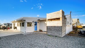 Una casa de dos pisos con camino de grava y una puerta azul.