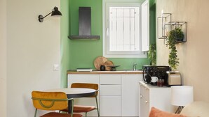 A compact kitchen with a window, a sink, a stove, and a small dining area with chairs. - Casa Hugo, studio apartment in San Niccolò district (Firenze)