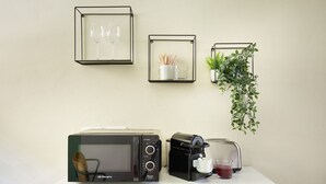 A kitchenette with a microwave, coffee maker, and framed pictures on the wall. - Casa Hugo, studio apartment in San Niccolò district (Firenze)
