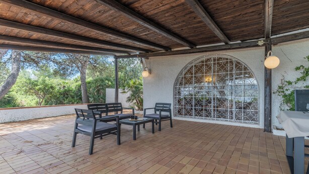 Une terrasse extérieure dotée d’un plancher en bois, un espace couvert avec un plafond en bois, et un aménagement avec des tables et des chaises.