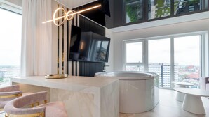 A modern kitchen with a built-in TV, a large window, and a view of the city. - RentPlanet - Apartamenty Quorum (Wroclaw)