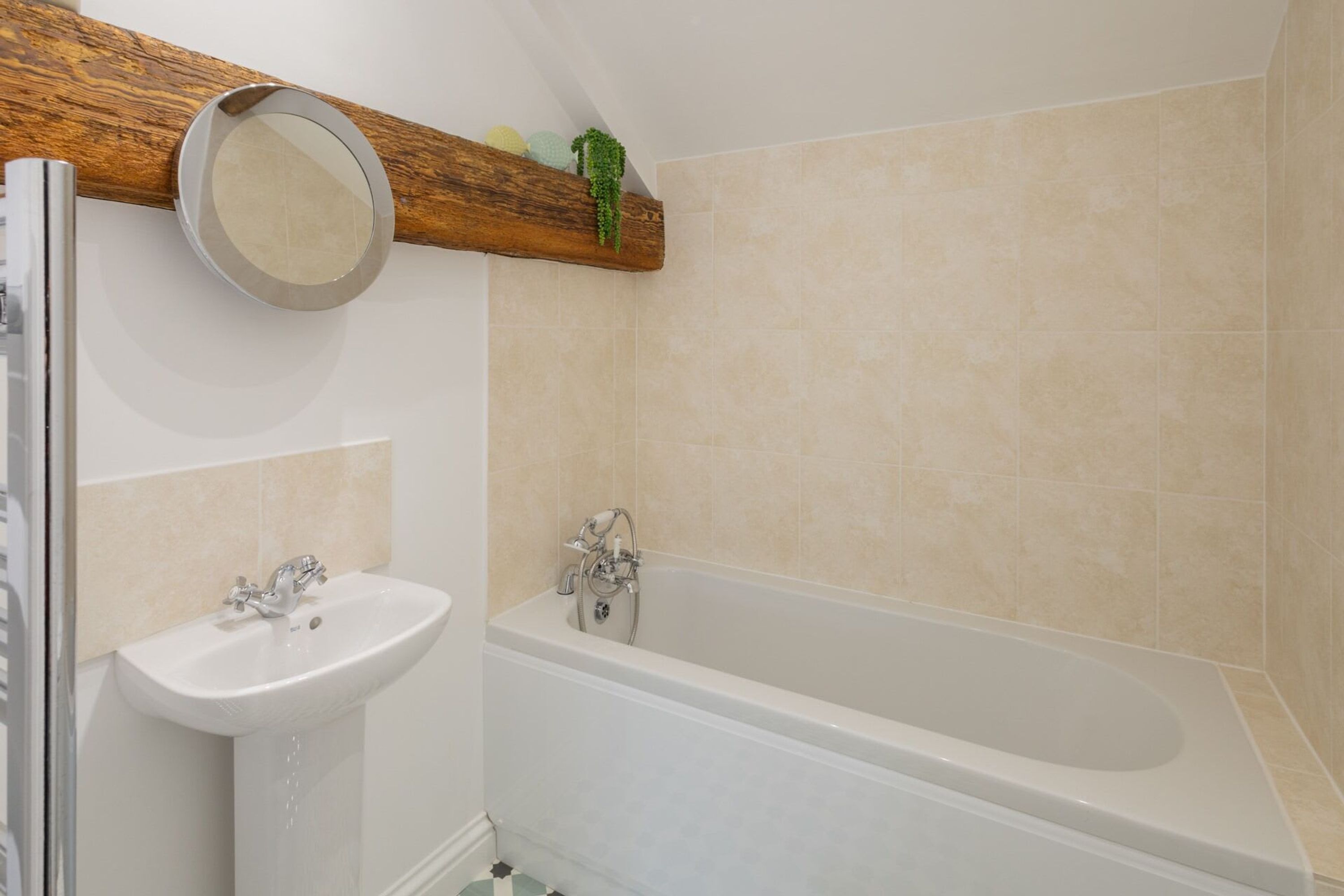 A bathroom with a bathtub, a sink, and a mirror.
