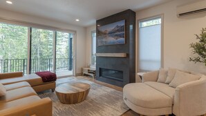 A modern living room with a fireplace, large windows, and a balcony. - cabin, hot tub! 3rd night free stay before 9/8/26 (Government Camp)
