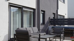 An outdoor seating area with a sofa and chairs, a table, and a sliding glass door. - Pet friendly home in Liznjan (Liznjan)