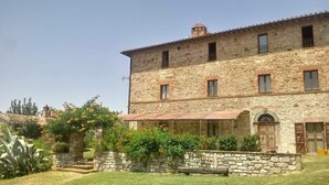 A stone building with a tiled roof, a covered entrance, and a stone staircase leading to the entrance. - Campo Al Vento (Monte Castello di Vibio)