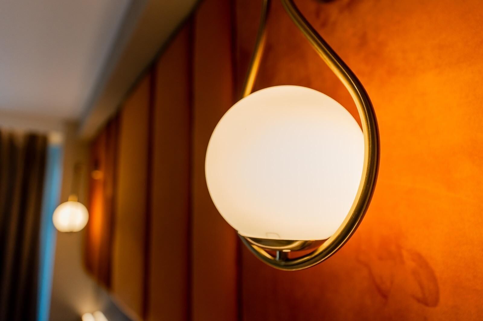 A wall-mounted light fixture with a spherical glass shade.