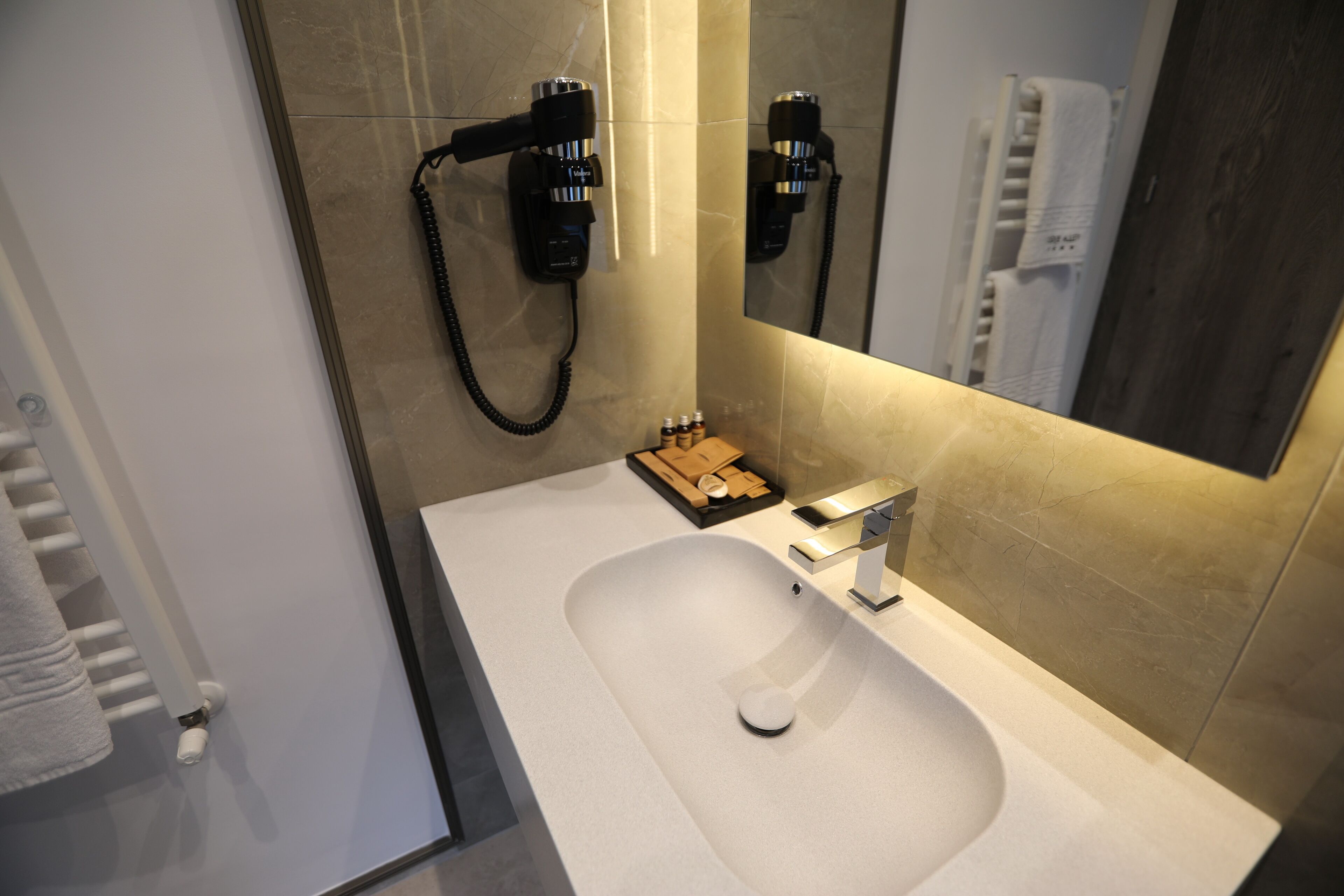 Un baño moderno con un lavabo grande, un cabezal de ducha manual y un espejo.