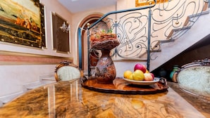 A dining table with a vase, fruit bowl, and a decorative metal railing. - Villa Bijoux (Ploiesti)